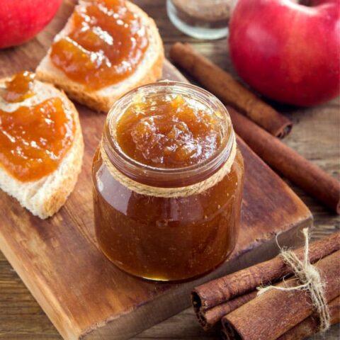jar of apple butter and toast on board