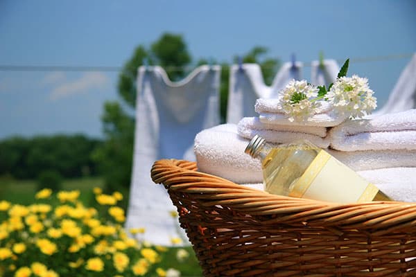 wicker basket of clean linen in front of a clothesline