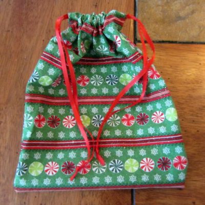 Never buy wrapping paper again! Sew this easy drawstring gift bag and save time, money, and the environment. Great use for fabric scraps or fat quarters.