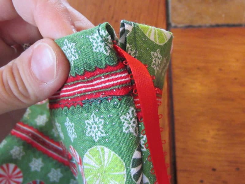 pulling ribbon through fabric gift bag