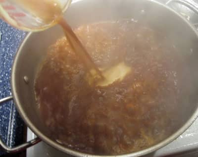 orange chicken sauce cooking in pan