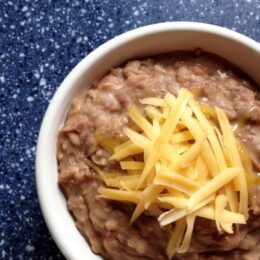 white bowl with refried beans and cheese