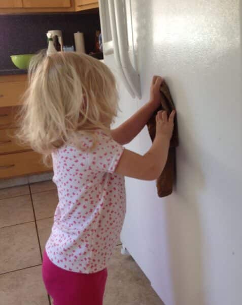 kid cleaning with natural cleaner spray