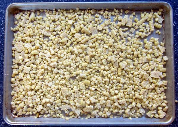 corn spread out on cookie sheet