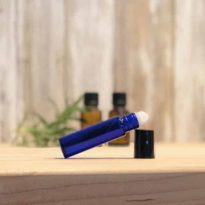 blue roller bottle with two essential oil bottles in background