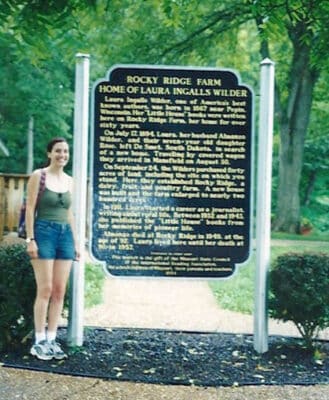 woman in front of Rocky Ridge Farm sign