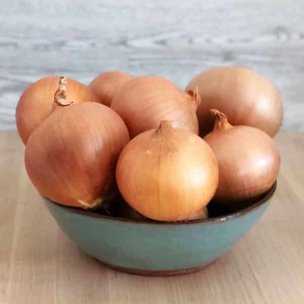 bowl of yellow onions on counter