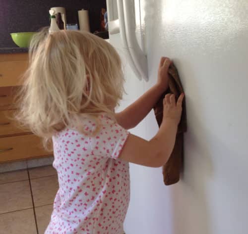 toddler wiping down fridge