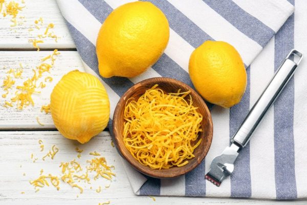 lemons and a bowl of lemon peel on a table