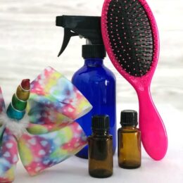 hair bow, spray bottle, hairbrush, essential oil bottles