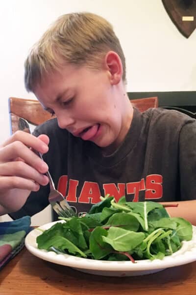 boy eating plate of salad