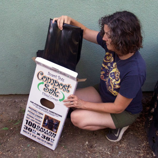 woman removing compost sak from box