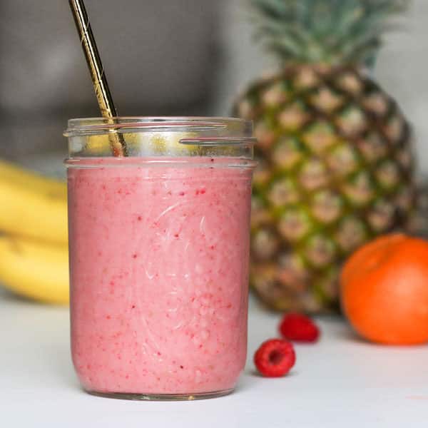 pink smoothie in glass jar with fruit