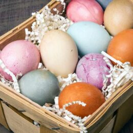 close up of colorful naturally dyed easter eggs in wicker basket