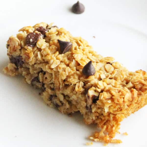 closeup of a homemade chocolate chip granola bar on white plate