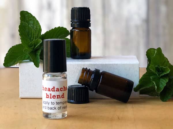 Essential oil bottles and mint leaves on a white box