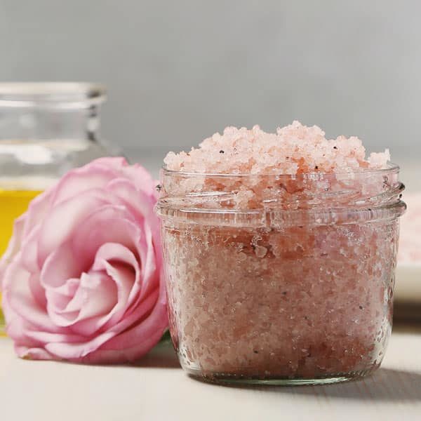 closeup of canning jar with pink bath salts and pink rose