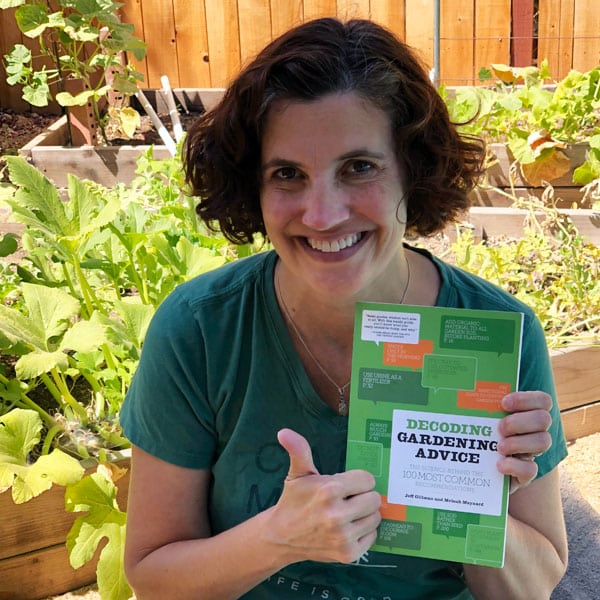 smiling woman holding gardening book