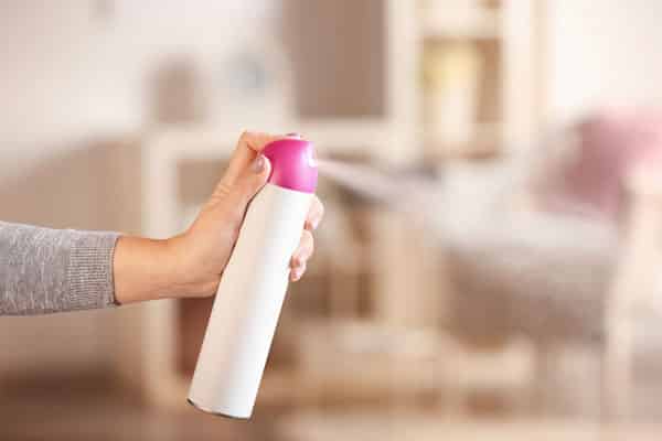 hand spraying air freshener spray
