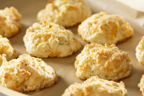 close up of cheddar bay biscuits on cookie sheet