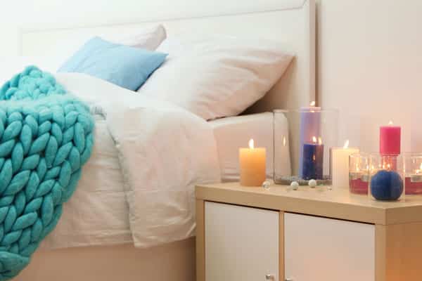 scented candles on table next to bed