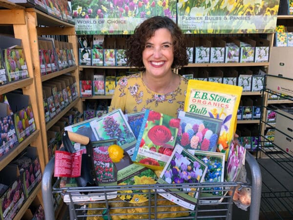 smiling woman with shopping cart of bulbs