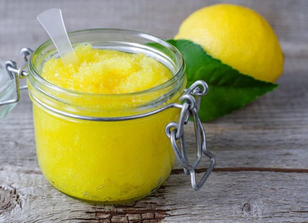 glass jar with lemon sugar scrub with lemon in background