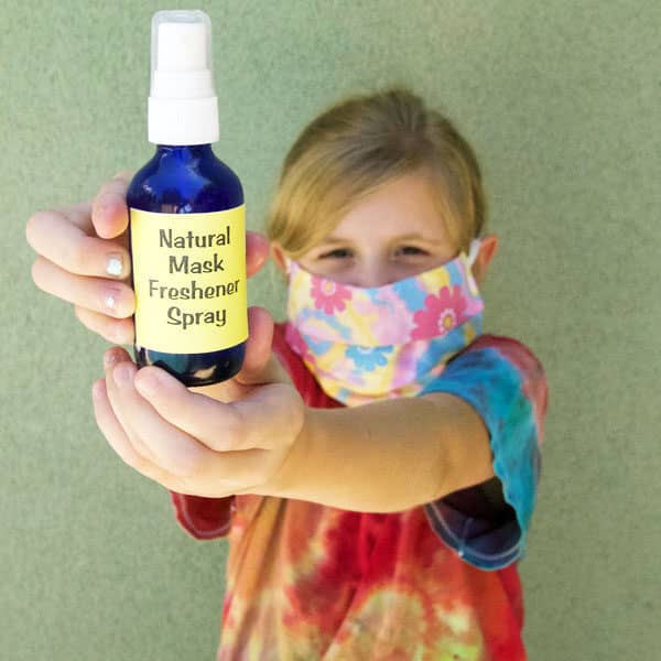 girl wearing mask holding spray bottle