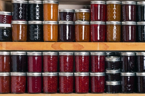 colorful jars of homemade jelly on pantry shelf