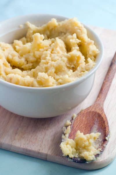 mashed potato in bowl with wooden spoon