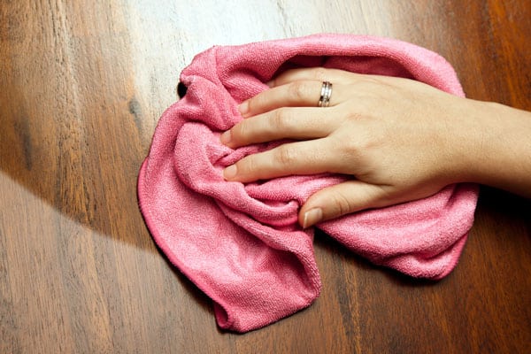 hand with cloth polishing wood