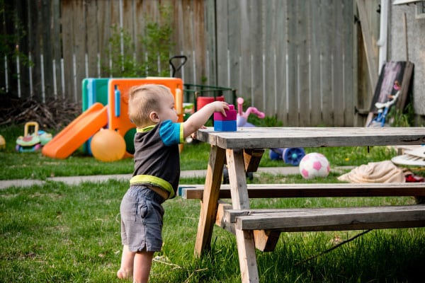 toddler grabbing blocks from outside table