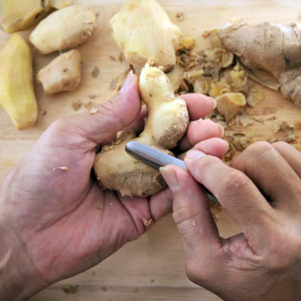 person peeling ginger
